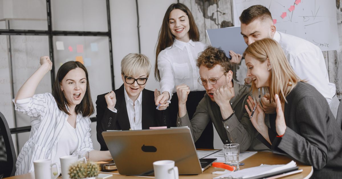 Group of diverse colleagues celebrating success in a modern office