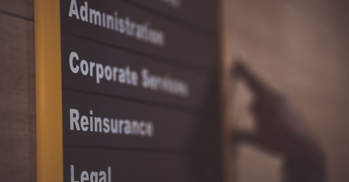 Close-up of an office directory sign showing administration and legal departments.