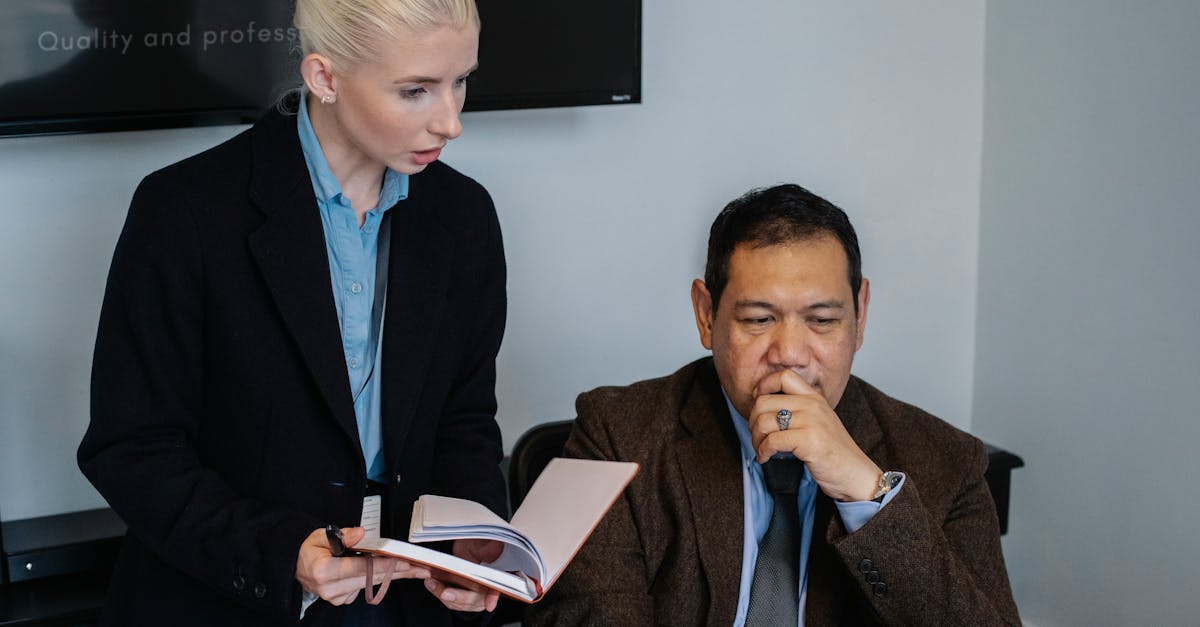 Serious multiracial coworkers in formal clothes gathering together and discussing details of business project while working in office