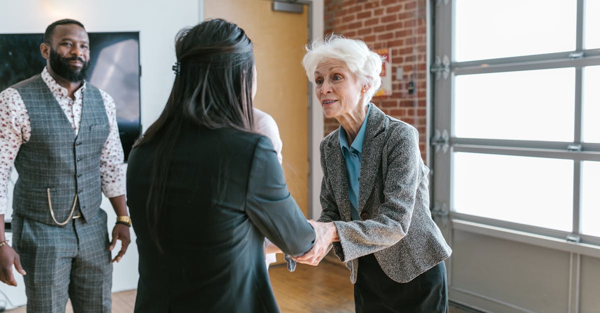 Three entrepreneurs meeting and shaking hands in a modern office setting.