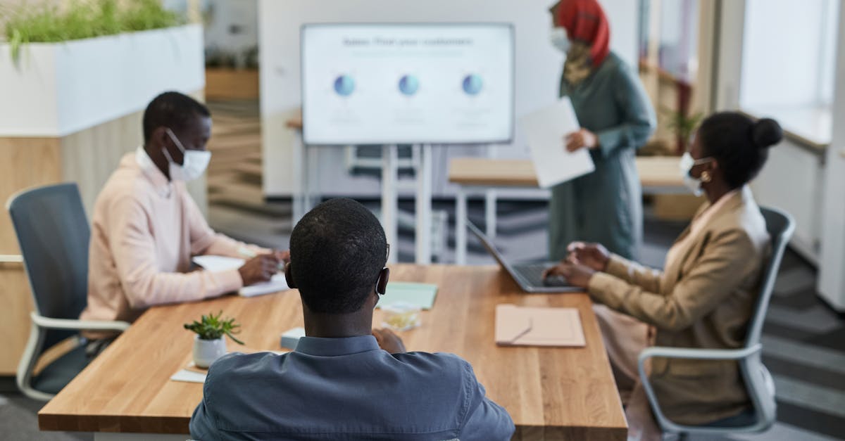 Diverse team in a modern office discussing a presentation in a conference room setting.