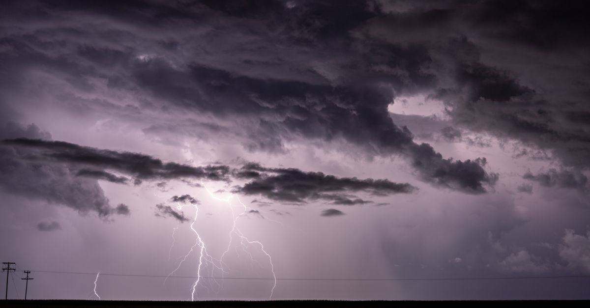 Dramatic stormy sky with intense lightning strikes illuminating dark clouds.