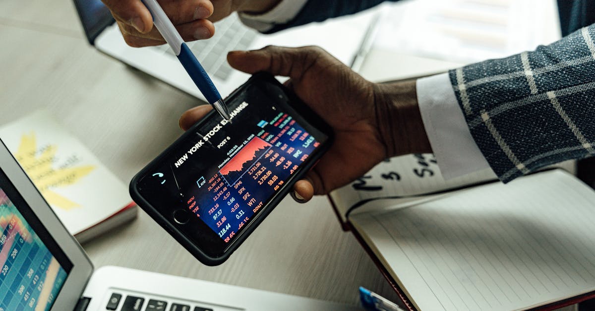 Business professionals analyzing stock exchange data on a smartphone in an office setting.