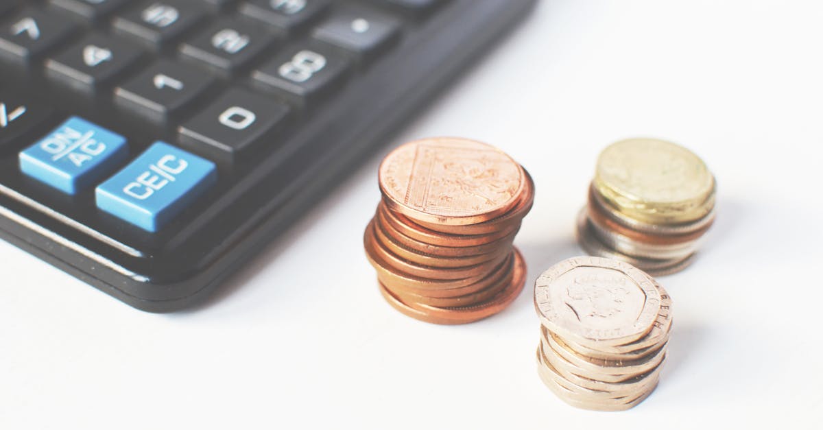 Close-up of stacked coins and a calculator symbolizing financial strategy and budgeting.