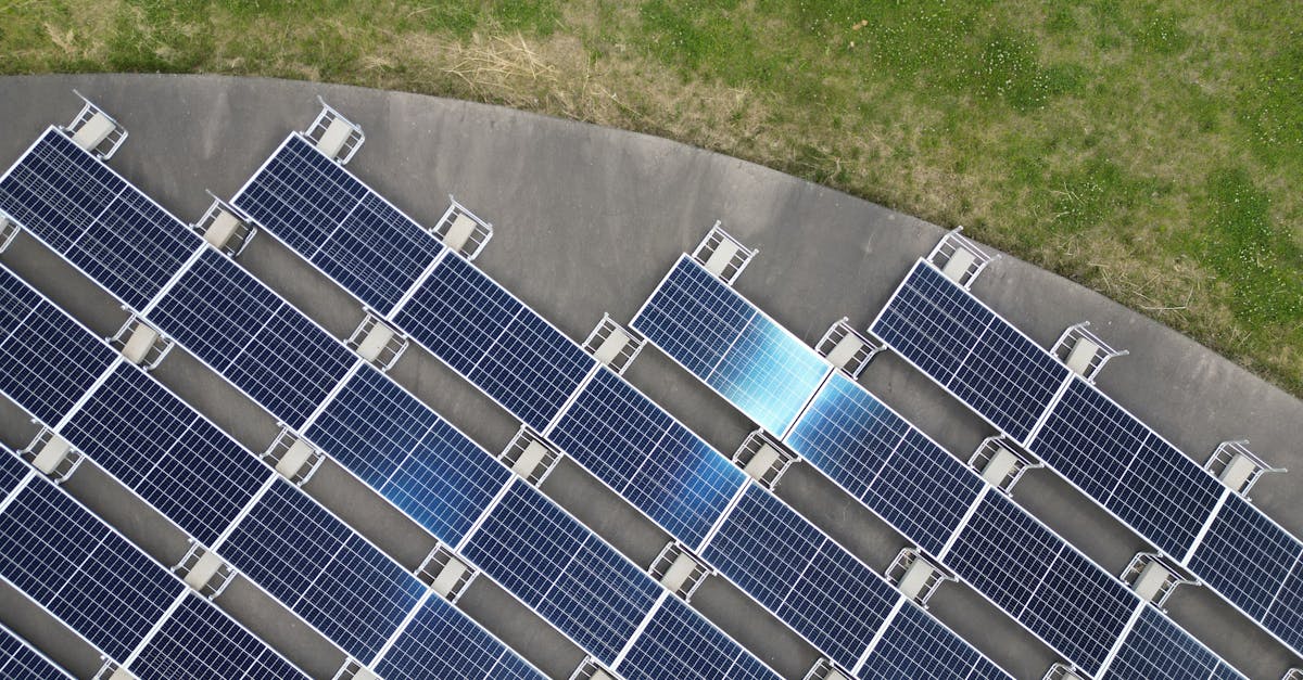 Top-down view of solar panels arranged on a green field, highlighting renewable energy.