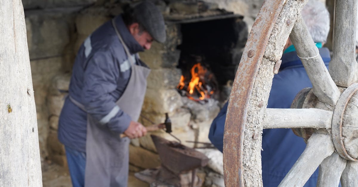 Blacksmith forging metal beside fire in rustic workshop, creating artisanal crafts.