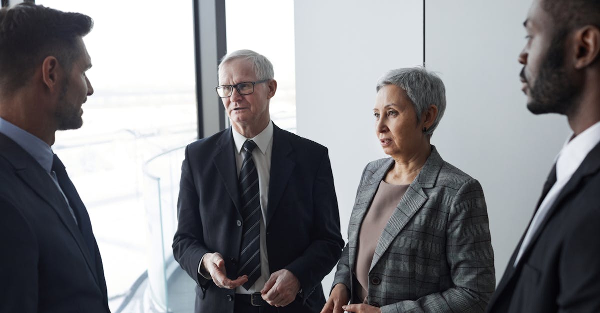 Group of business professionals in a formal meeting setting discussing strategy indoors.