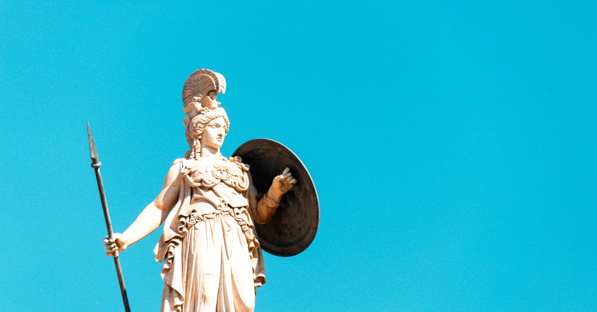 A photo of the Athena statue in Athens, showcasing its intricate details against a bright blue sky background.