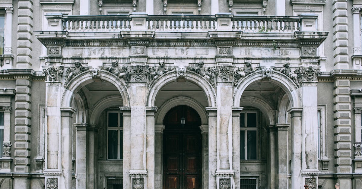 Exterior of famous palace with columns and sculptures near ornamental doorway under balcony