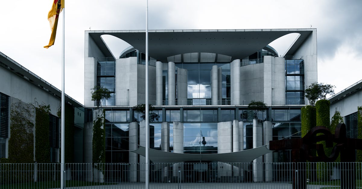 Contemporary architecture of a government building with German flag under cloudy skies.