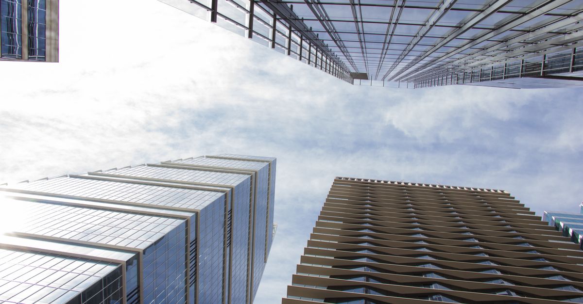 Low-angle view of high-rise buildings against a bright blue sky in Austin, Texas.