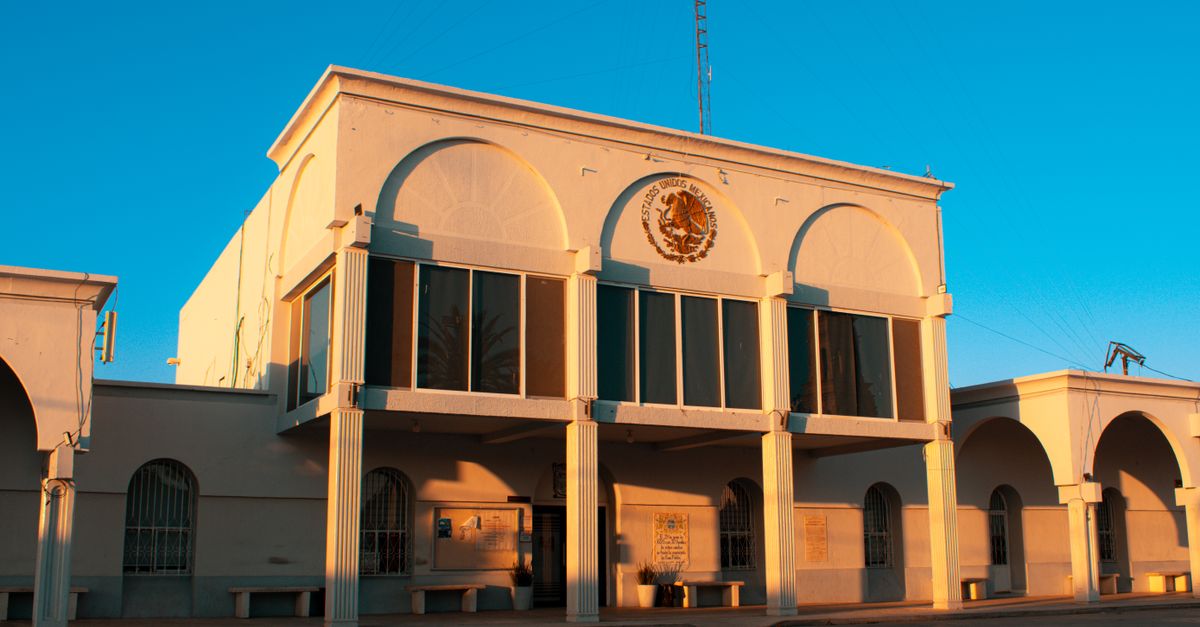 Colonial-style building in Pedro Meoqui, Mexico, featuring arches and a sunny facade.