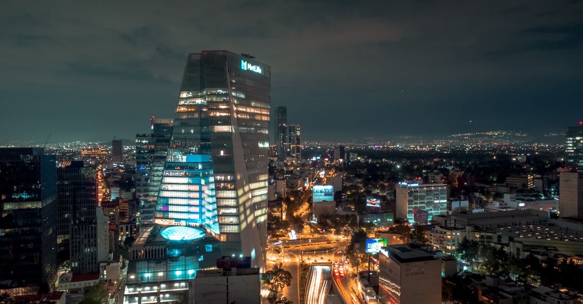 A stunning night view of Mexico City's skyline with brightly lit skyscrapers and urban landscape.