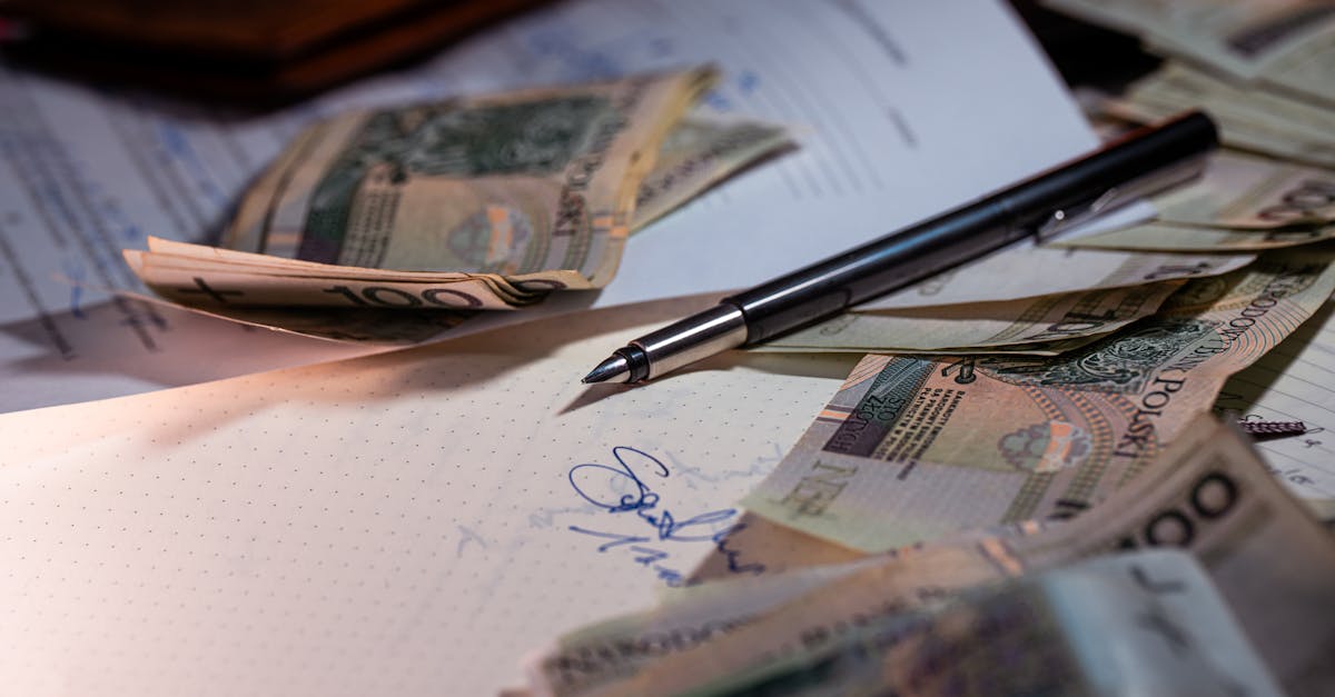 Overhead view of Polish banknotes, documents, and a pen on a desk, highlighting financial planning.