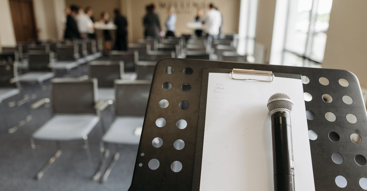 Close-up of a microphone on a stand in a conference room setting.