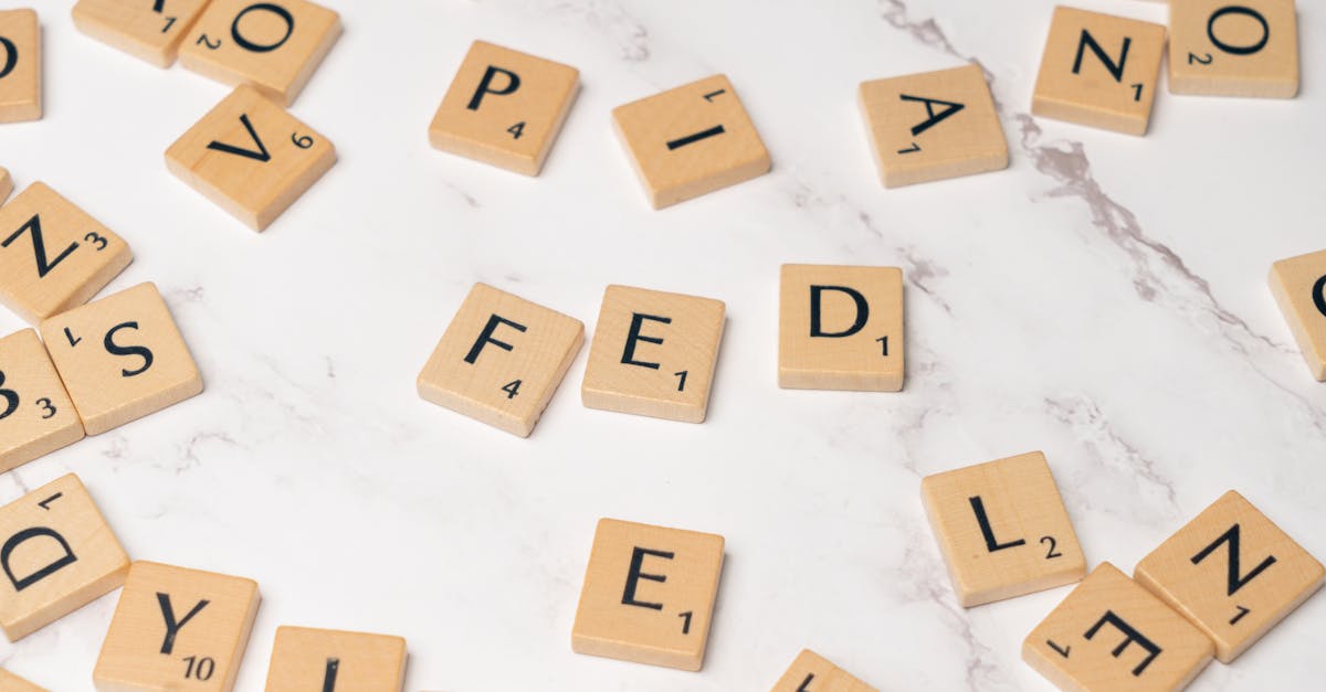 Scrabble tiles arranged to spell 'FED' on a marble surface, symbolizing finance.
