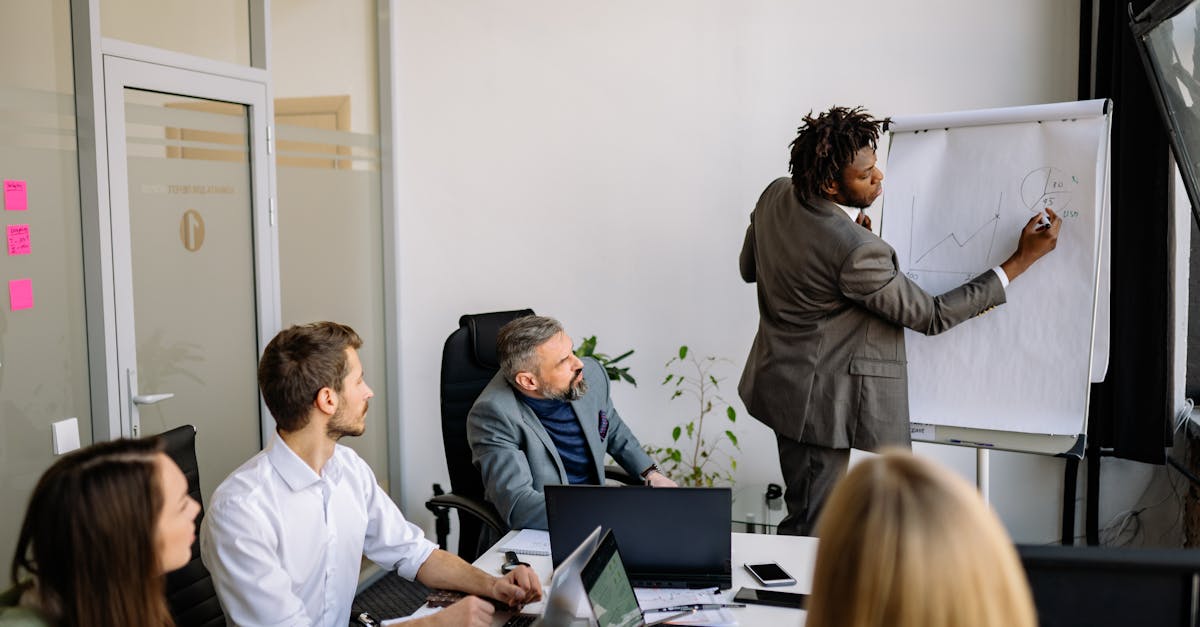 A diverse team in a modern office engaged in a strategic business meeting led by a presenter.