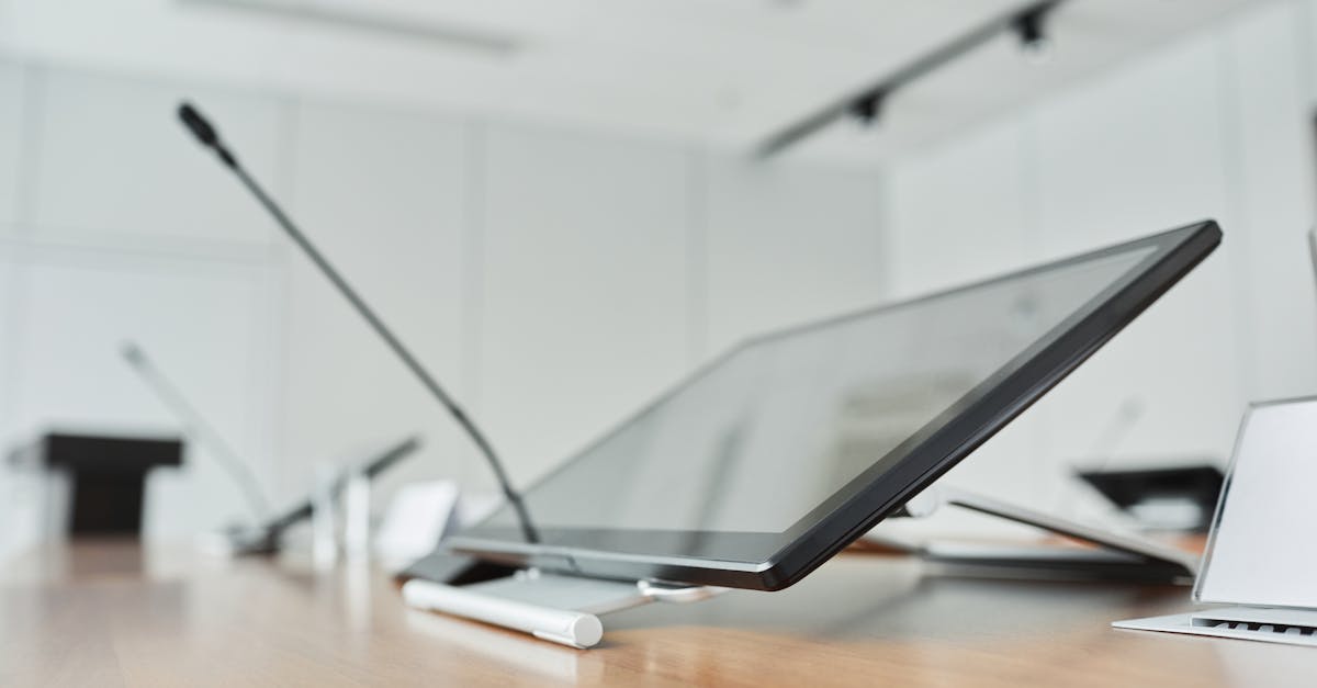Close-up of a modern conference room with a digital screen and microphones.