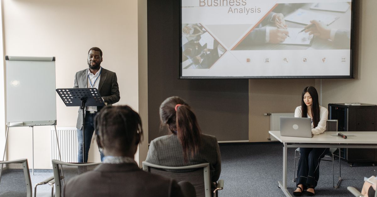 Business seminar with a speaker and audience in a conference room.