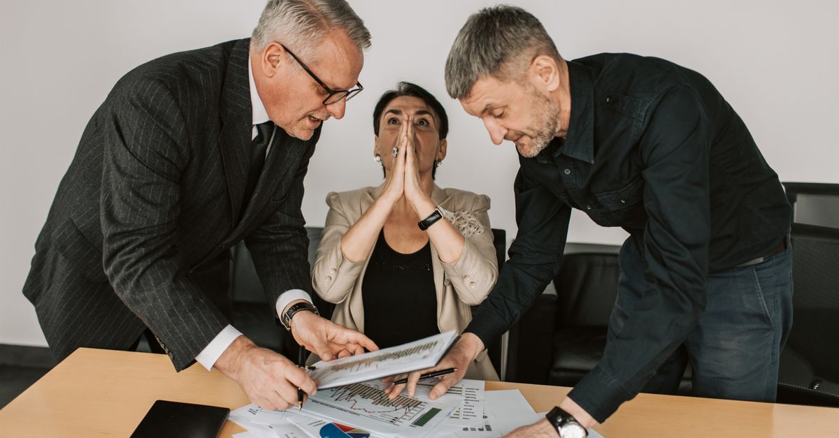 A group of diverse professionals engaged in a focused discussion in a modern office setting.