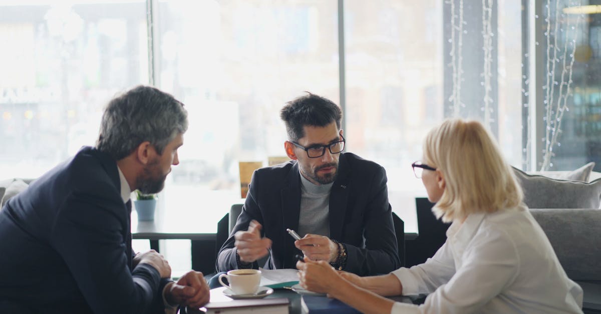 Business professionals engaged in a meeting at a café, sharing ideas and discussion.