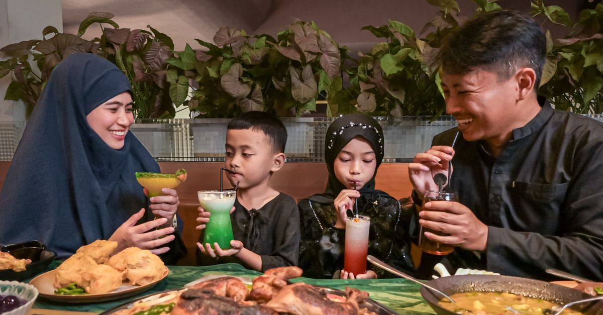A family sharing drinks and traditional food in an Indonesian restaurant, featuring a warm and joyful atmosphere.