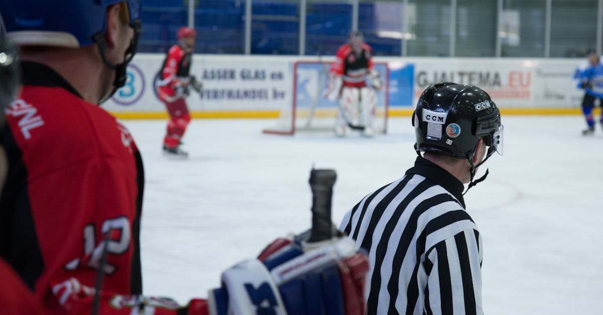 Dynamic shot of an ice hockey game with active players and attentive referee at an indoor rink.