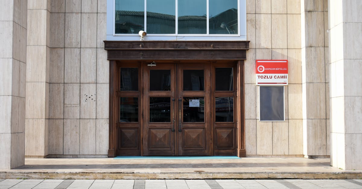 Wooden doors leading into a modern mosque facade, featuring traditional elements and contemporary design.