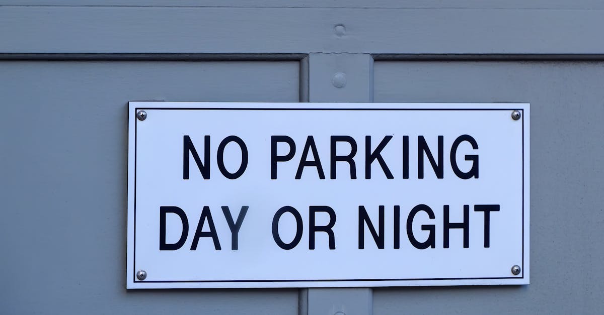 Close-up of a no parking sign mounted on a blue painted wall, emphasizing prohibition and warning.