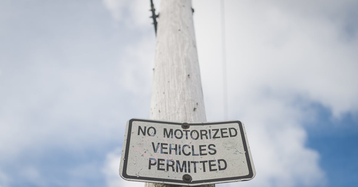 A street sign prohibiting motorized vehicles, mounted on a post against a blue sky.