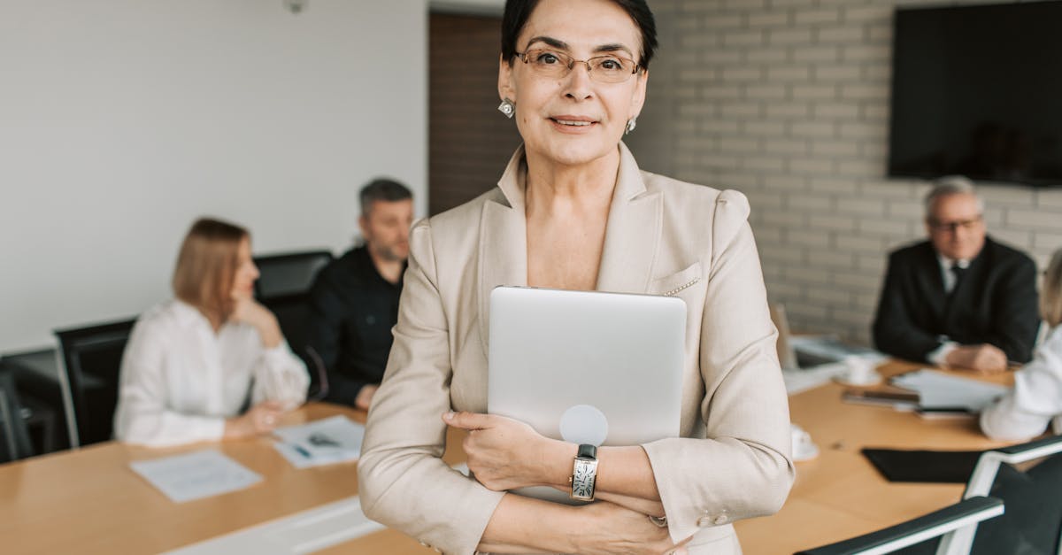 Professional businesswoman holding a tablet in a corporate meeting setting.