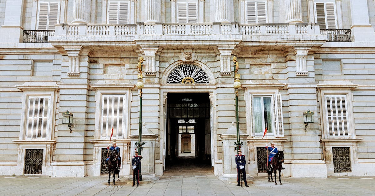 Guards and cavalry stand at the Royal Palace of Madrid entrance, showcasing Spanish heritage.
