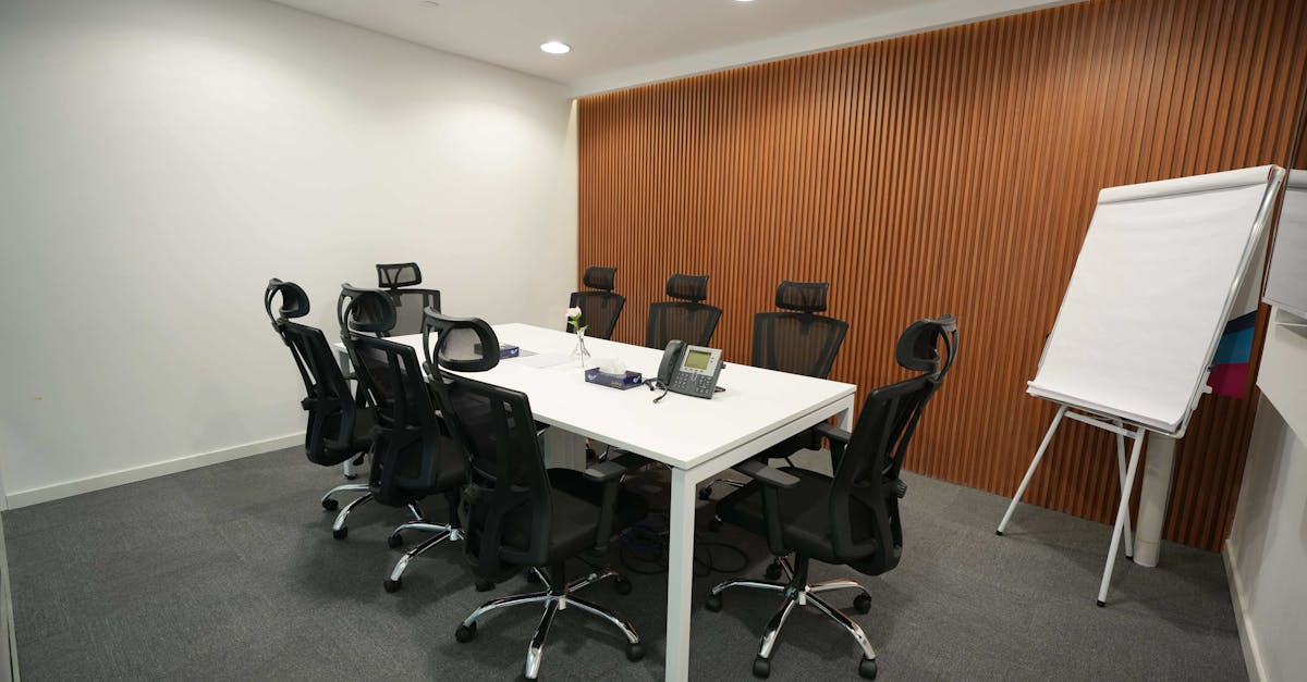 Spacious meeting room featuring ergonomic chairs, a large table, and a flip chart.