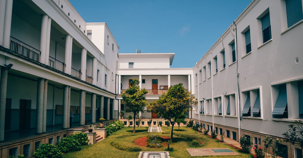 Elegant university building with garden courtyard in Rabat, Morocco under clear blue sky.