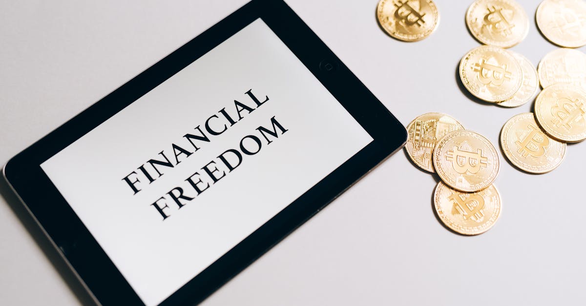 Tablet showing 'Financial Freedom' with gold bitcoins nearby, symbolizing cryptocurrency investment.