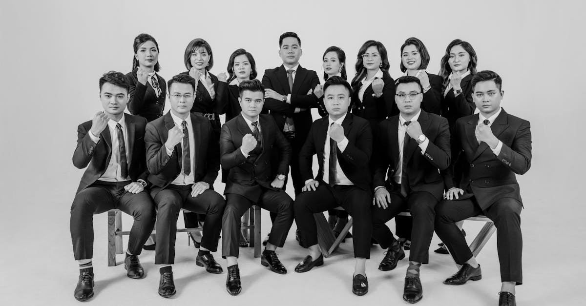 A group of Asian professionals in suits posing confidently in a studio setting.