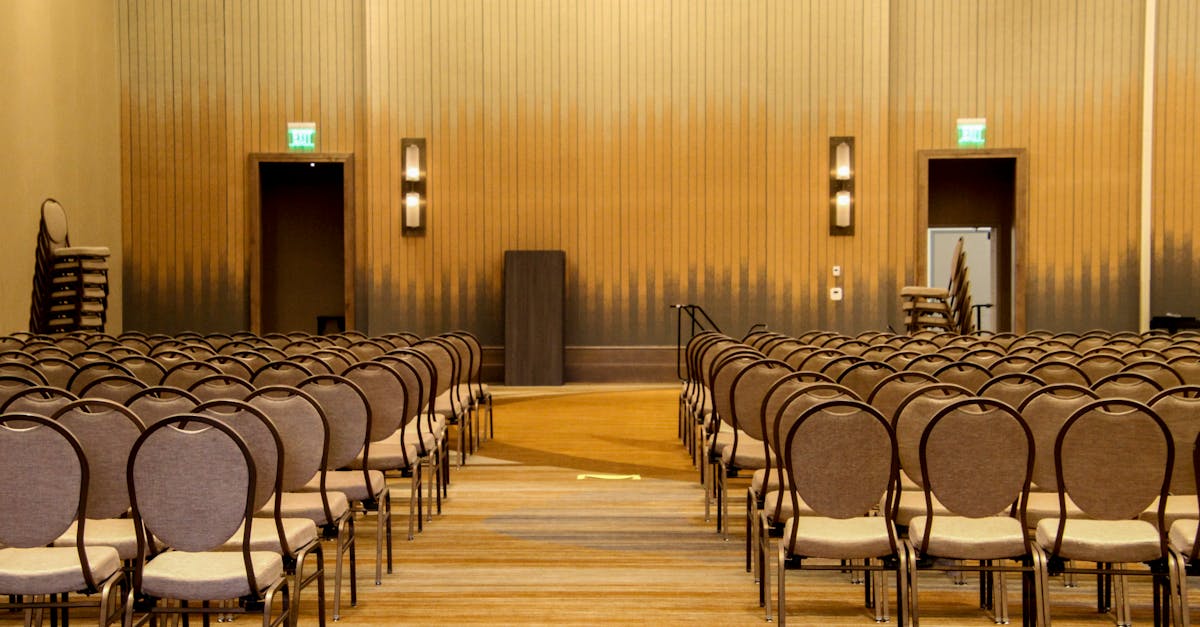 Spacious empty conference room with neatly arranged chairs ready for an event.