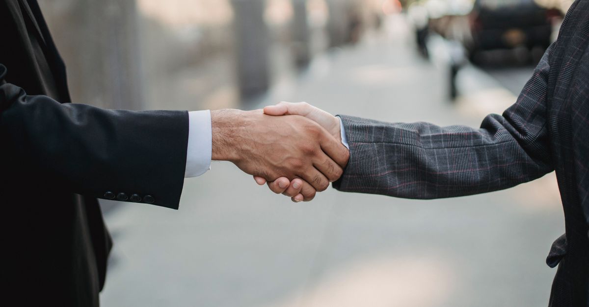 Close-up of a business handshake between professionals outdoors.