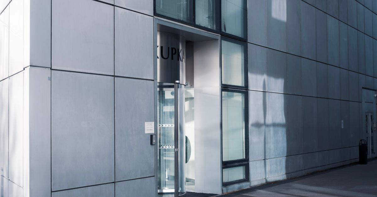 Sleek modern architecture featuring a glass entrance with reflective facade, showcasing contemporary design.