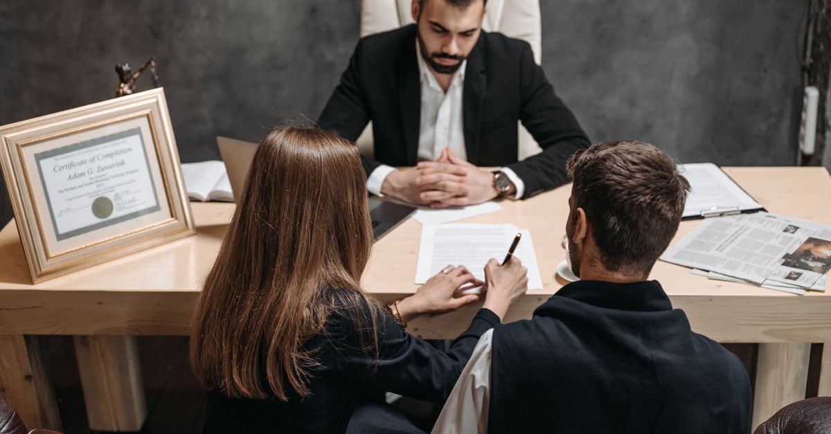 A lawyer discusses legal documents with clients in an office setting.