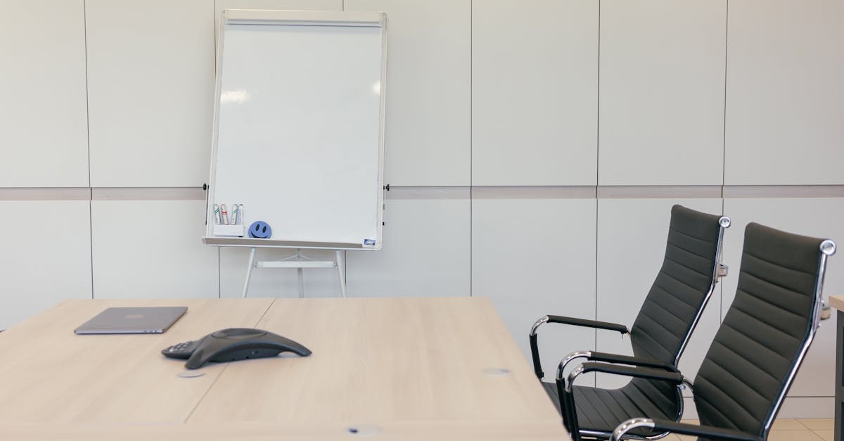 Sleek conference room with chairs, table, and whiteboard ready for a meeting.