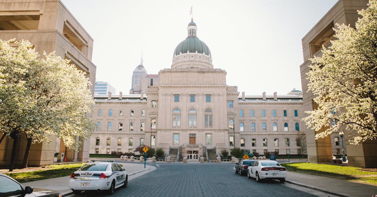 Historic Indiana State Capitol Building in Indianapolis during springtime with blooming trees.