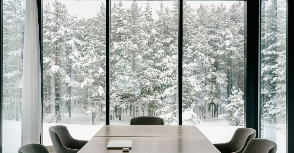 Elegant conference room featuring large windows with a snowy forest view, perfect for serene business meetings.