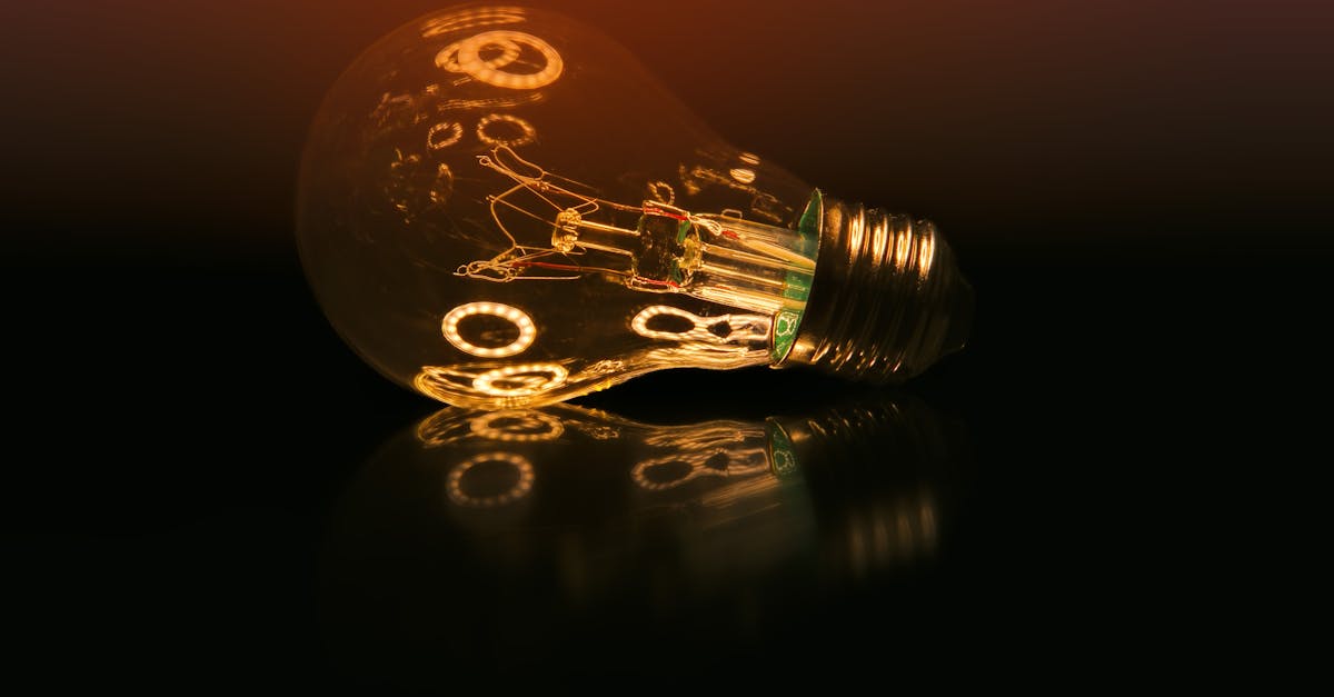 A glowing light bulb on a dark reflective surface creating a warm ambient atmosphere.