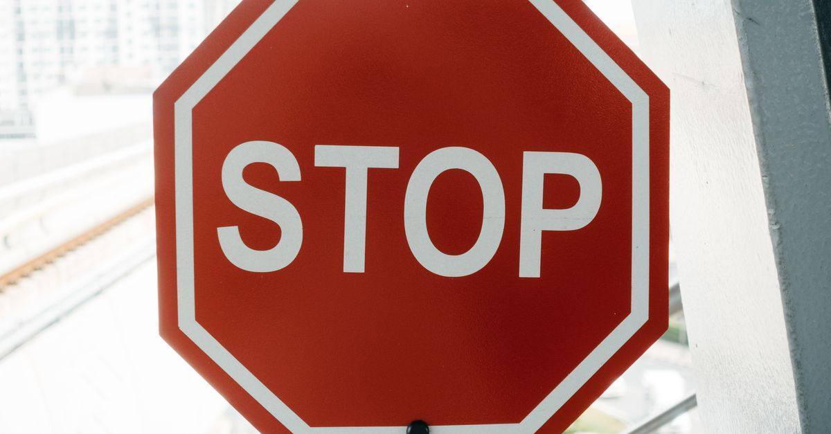Close-up of a red stop sign with urban background, emphasizing safety and caution.