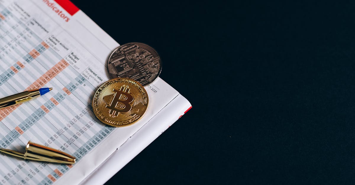 A close-up of Bitcoin with financial indicators and a pen on a black surface.