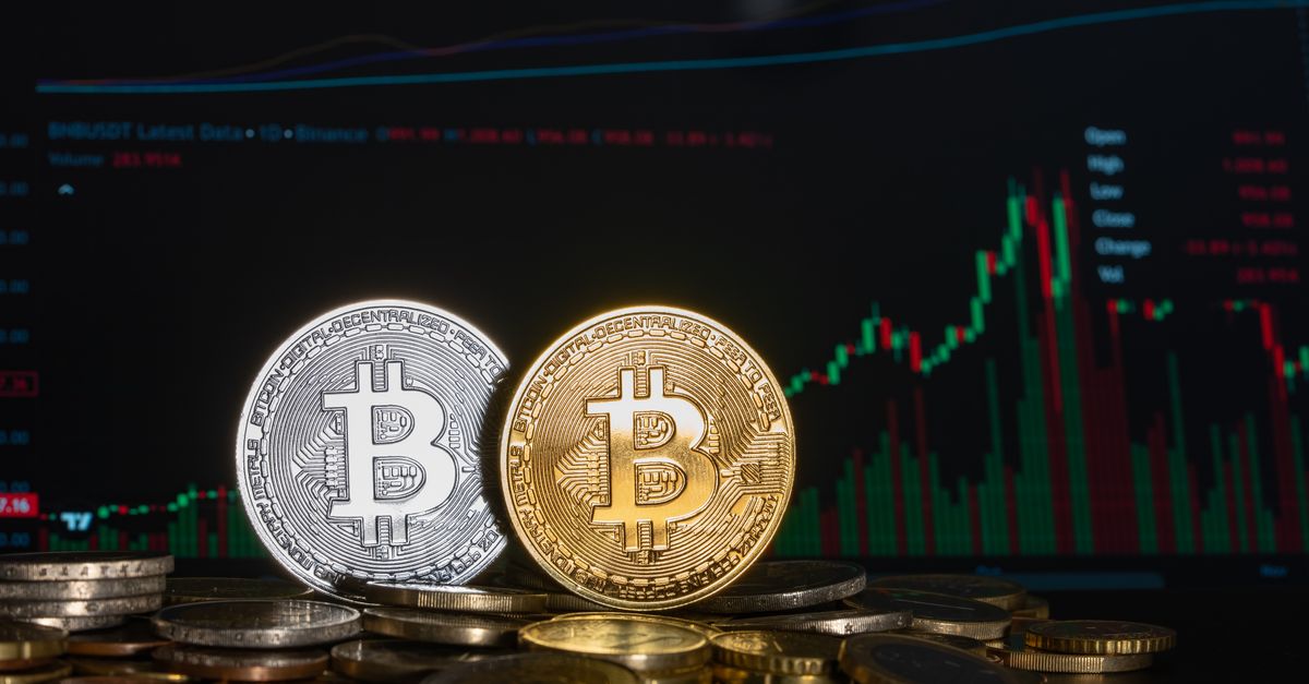 Golden and silver Bitcoin coins against a financial graph display, highlighting cryptocurrency investment trends.