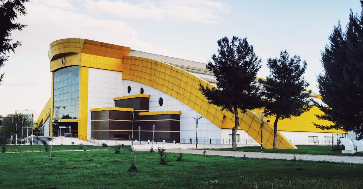 A contemporary building in Gaziantep with unique architecture surrounded by green lawns and trees.
