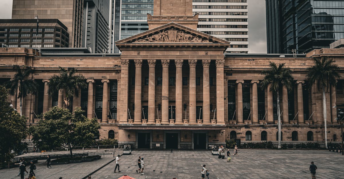 A view of Brisbane City Hall with urban surroundings and pedestrians in the plaza.