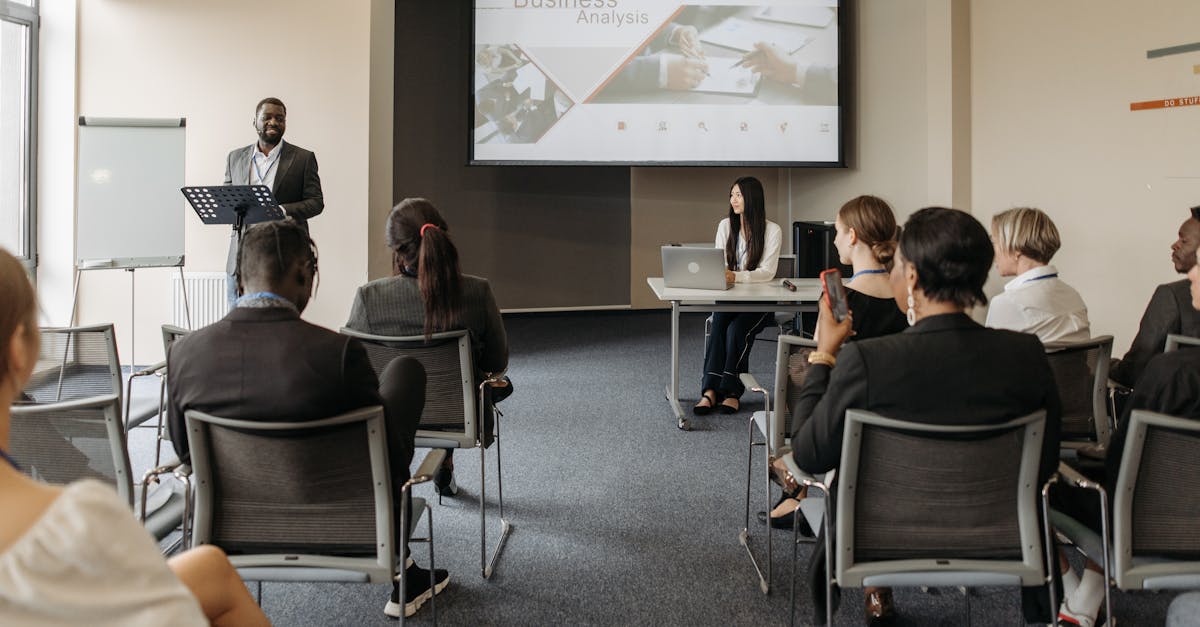 A diverse group of adults attending a presentation in a conference room setting.